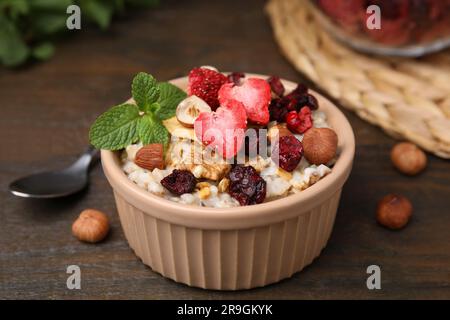 Farina d'avena con frutta secca liofilizzata, noci e menta su tavolo di legno, primo piano Foto Stock