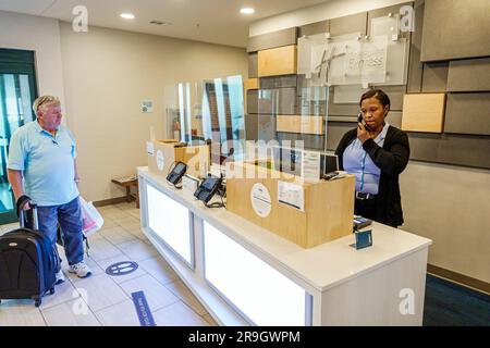Macon Georgia, Holiday Inn Express & Suites Macon-West IHG hotel, reception lobby, ospiti che arrivano bagagli uomo, donna afro-americana nera c Foto Stock