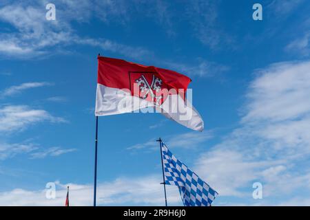 La bandiera vola contro un cielo blu bianco in una giornata estiva in Baviera Foto Stock