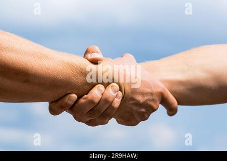 Stretta di mano amichevole, saluto degli amici, lavoro di squadra, amicizia. Soccorso, aiuto gesto o o mani. Due mani, aiutando il braccio di un amico, lavoro di squadra. Aiutare Foto Stock