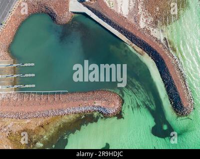 Vista aerea di una rampa costiera per barche circondata da frangiflutti rocciosi a Port Hughes, sulla penisola di Yorke, nell'Australia meridionale Foto Stock