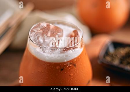 Tè al latte tailandese freddo in vetro, a fuoco selettivo Foto Stock
