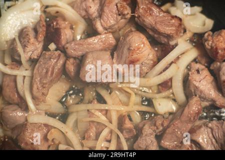 Goulash di carne fritto con carote e cipolle. Brasato di carne in padella. Foto Stock