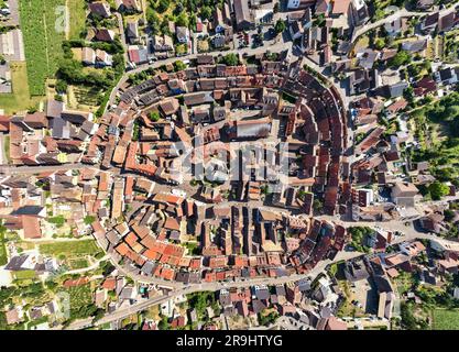 Vista dall'alto del villaggio di Eguisheim nella provincia dell'Alsazia, Francia. Luogo pittoresco di sera. Tiro aereo con drone Foto Stock