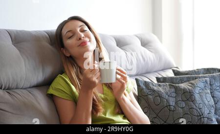 Stile di vita rilassate la felice donna asiatica sul divano di lusso dell'hotel Living banner panoramico. Casa comfort viaggio estivo vacanza libera ragazza respira aria pulita su S Foto Stock