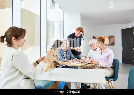 Uomo d'affari che discute di documenti con colleghi maschi e femmine Foto Stock