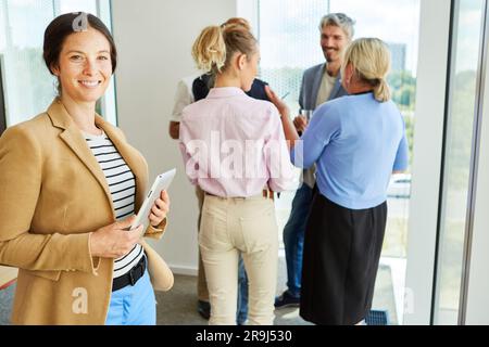 Ritratto di una donna d'affari sorridente in piedi con un tablet PC Foto Stock