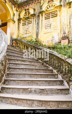 BAC ha, Vietnam-aprile 2023; vista dall'angolo basso delle scale nello storico Palazzo Hoang A Tuong fatiscente, con una miscela di architettura europea e cinese Foto Stock