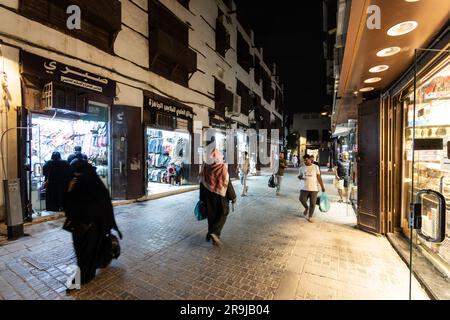 Gedda, Arabia Saudita - gennaio 26 2023: La gente cammina di notte per le strade del suq di Gedda, tradizionale città vecchia di al-Balad, in Arabia Saudita Foto Stock