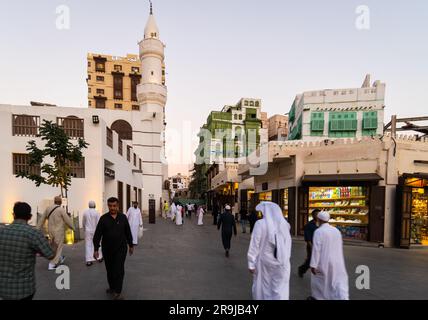 Gedda, Arabia Saudita - persone vestite con abiti tradizionali camminano davanti alla moschea al Ma'amar nella città vecchia di Gedda, al-Balad, in Arabia Saudita Foto Stock