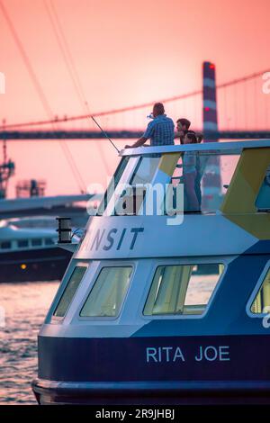 Halifax Transit Ferry sullo sfondo del McDonalds Bridge e Tufts Cove Generation Station Chimneys. Halifax, nuova Scozia, Canada - GIUGNO 2022 Foto Stock