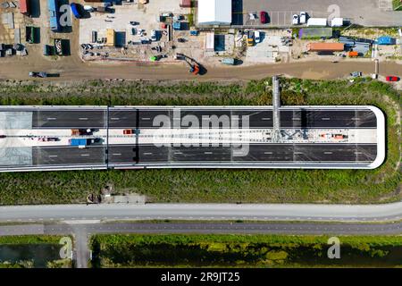 Foto aerea di un drone di un'autostrada che entra in un tunnel visto dall'alto. Foto Stock