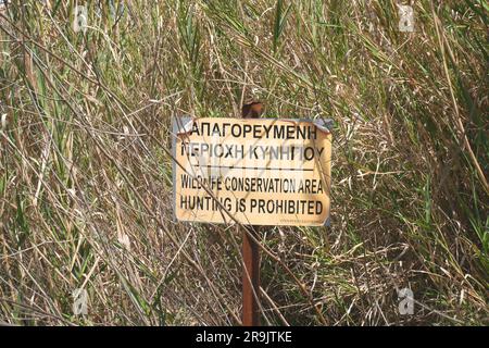 Cartello in greco e inglese con scritto Wildlife Conservation area Hunting is prohibited, Episkopi, vicino a Paphos, Repubblica di Cipro Foto Stock