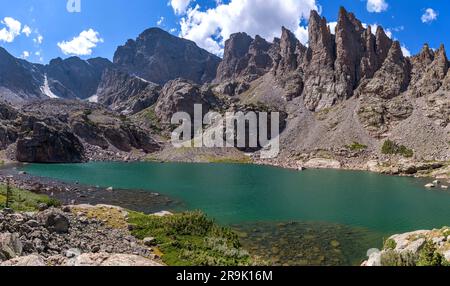 Sky Pond - Panorama panoramica dello Sky Pond trasparente e colorato, con Taylor Peak, Taylor Glacier e Sharkstooth che torreggiano sulla riva, RMNP, CO, USA. Foto Stock