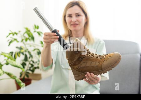 Ritratto di un giovane tecnico protesico che tiene la gamba protesica controllandola per la qualità e apportando regolazioni mentre lavora in un moderno laboratorio Foto Stock