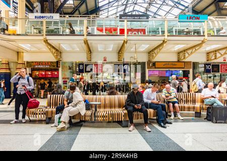 La gente sedeva sulle panchine nell'atrio della stazione di Liverpool Street a Londra, Regno Unito Foto Stock