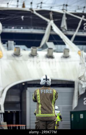 Fireman assiste alla scena della O2 Arena, dove la tela cerata è stata strappata a causa della tempesta Eunice venerdì 18 febbraio 2022 Foto Stock