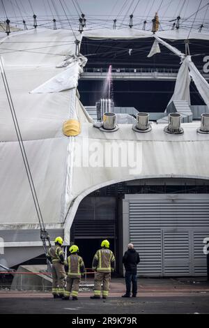 Fireman assiste alla scena della O2 Arena, dove la tela cerata è stata strappata a causa della tempesta Eunice venerdì 18 febbraio 2022 Foto Stock