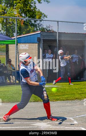 Una giocatrice che sta per colpire la palla durante una partita di Fastball sull'Isola di Vancouver in Canada Foto Stock