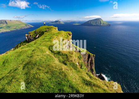 Fai un'escursione in cima alle scogliere ammirando l'isola di Koltur nel mezzo dell'oceano, Nordradalur, Streymoy Island e le Isole Faroe Foto Stock