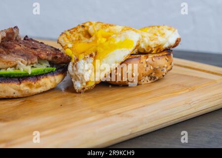 Panino per la colazione, pancetta di maiale, avocado e uova isolate, studio fotocopie, sfondi per la nutrizione della colazione, diete di carboidrati, fast food Foto Stock