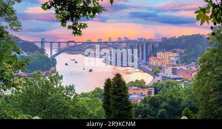Splendido paesaggio del famoso Arrabida Arch Bridge con escursioni di arrampicata nella città di Porto illuminato al tramonto in Portogallo Foto Stock