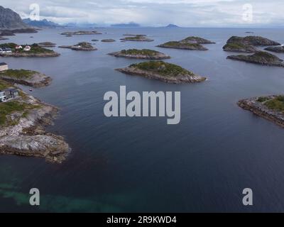 Una vista aerea di un gruppo di piccole isole al largo della costa della Norvegia, circondate da un tranquillo oceano blu Foto Stock