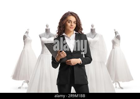 Wedding planner che tiene un appunti e posa di fronte a abiti da sposa isolati su sfondo bianco Foto Stock