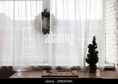 Frese da cucina e albero di Natale decorativo su tavolo in legno al chiuso Foto Stock