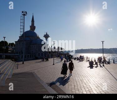 Sagoma della Moschea di Şemsi Pasha in una serata estiva nella città di Uskudar, Istanbul, Turchia. La gente cammina e pesca lungo il Mare del Bosforo Foto Stock