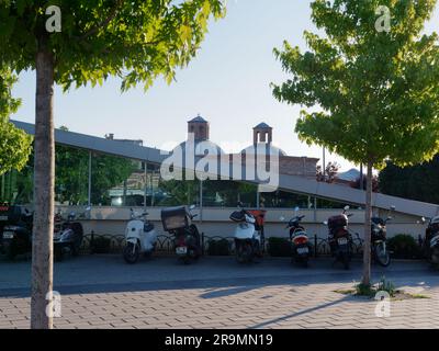 Moto e scooter parcheggiati accanto a un edificio della metropolitana con tetto inclinato una sera nella città di Uskudar, sul lato asiatico di Istanbul, Turchia Foto Stock