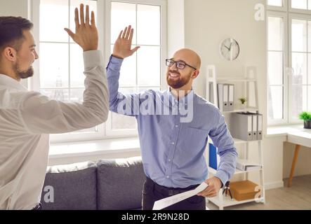 Uomo d'affari che dà cinque al suo partner alla riunione in ufficio Foto Stock