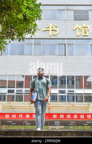 (230628) -- CHANGSHA, 28 giugno 2023 (Xinhua) -- Magoua Ardain esce da una biblioteca presso la Central South University di Changsha, nella provincia di Hunan della Cina centrale, 14 giugno 2023. Il ventiquattrenne Camerun Magoua Ardain è senior presso il College of Mechanical and Electrical Engineering (CMEE) della Central South University. Ardain si è laureato in progettazione meccanica, produzione e automazione, cosa che gli piace molto e svolge un ottimo lavoro. Può anche parlare molto fluente cinese e ha molti amici a scuola. Sono molto felice e condivido sempre la mia vita qui con la mia famiglia, Arda Foto Stock