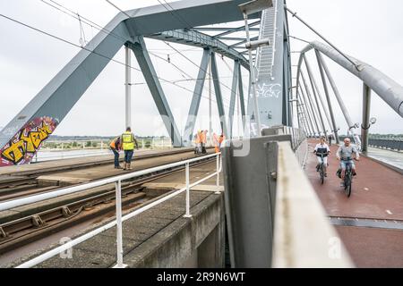 NIJMEGEN - Paesi Bassi, 28/06/2023, i dipendenti ispezionano il ponte ferroviario sul Waal. Per motivi di sicurezza, nessun treno passa sopra il ponte ferroviario, il che significa che non è possibile alcun traffico ferroviario tra Arnhem e Nijmegen. ANP JEROEN JUMELET netherlands Out - belgium Out Foto Stock