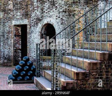 Una scala in cemento che conduce ad un muro di mattoni sul lato di un edificio nel Fort Macon State Park Foto Stock