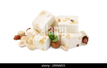 Pezzi di torrone, noci e menta deliziosi su sfondo bianco Foto Stock