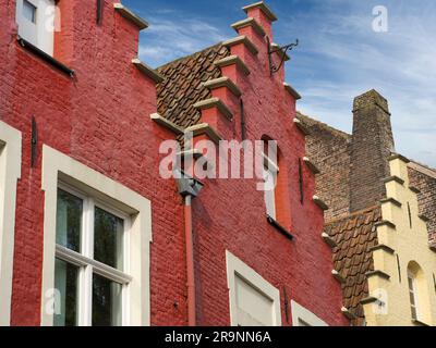 Qui vediamo i tetti in stile fiammingo e i frontoni a gradini a Walplein, Bruges. Questo è un posto piuttosto affollato con molti ristoranti, bar e statue, mos Foto Stock