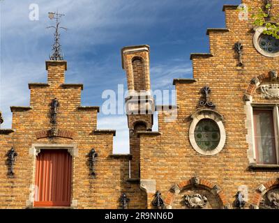 Qui vediamo i tetti in stile fiammingo e i frontoni a gradini a Walplein, Bruges. Questo è un posto piuttosto affollato con molti ristoranti, bar e statue, mos Foto Stock