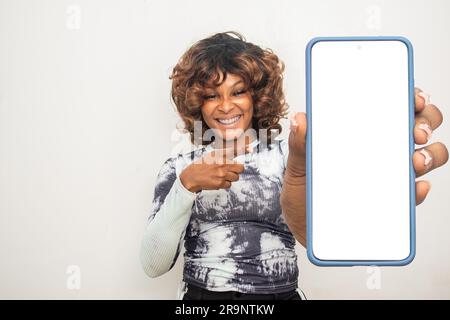 giovane donna nera che punta al suo grande schermo del telefono Foto Stock