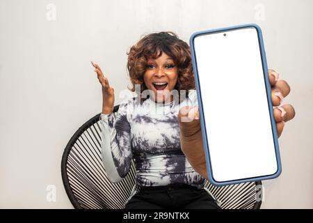 donna africana che mostra un grande schermo del telefono che sembra sorpreso Foto Stock