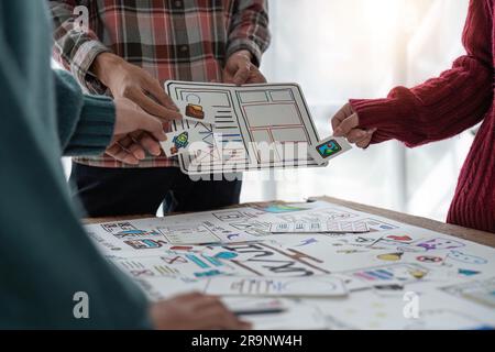 Un gruppo ravvicinato di designer del team creativo asiatico che programmano i progetti partecipano a tutte le fasi della progettazione dell'interfaccia utente e dell'interfaccia utente Foto Stock