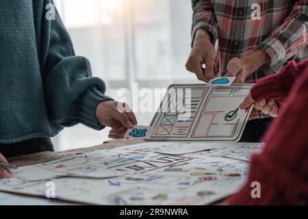 Un gruppo ravvicinato di designer del team creativo asiatico che programmano i progetti partecipano a tutte le fasi della progettazione dell'interfaccia utente e dell'interfaccia utente Foto Stock