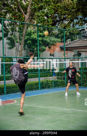 Bangkok, Thailandia. 25 giugno 2023. I giocatori locali thailandesi di Sepak Takraw vengono visti durante una partita al Benchasiri Public Park in Sukhumvit Road. Sepak Takraw, chiamato anche kick volley o Thailand's Acrobatic Volley, è uno degli sport più popolari del sud-est asiatico che viene giocato con una palla fatta di rattan o plastica sintetica dove i giocatori possono solo toccare la palla con i piedi, il corpo o la testa. (Foto di Nathalie Jamois/SOPA Images/Sipa USA) credito: SIPA USA/Alamy Live News Foto Stock