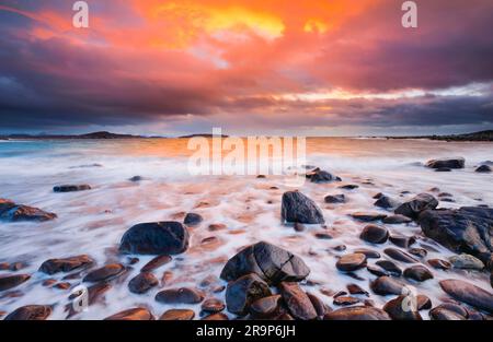 Tramonto su una spiaggia rocciosa vicino ad Achiltibuie, sulla costa occidentale della Scozia. Gran Bretagna Foto Stock