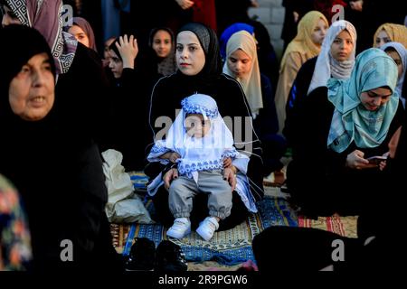 Gaza, Palestina. 28 giugno 2023. Una ragazza palestinese siede con sua madre al momento della preghiera Eid al-Adha il primo giorno di Eid al-Adha a Khan Yunis, nella Striscia di Gaza meridionale. Credito: SOPA Images Limited/Alamy Live News Foto Stock