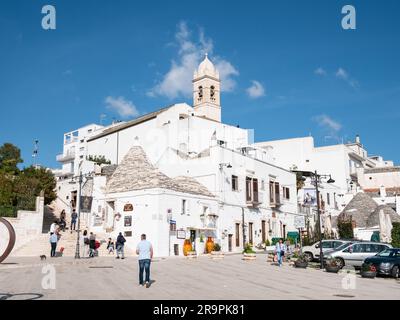ALBEROBELLO, ITALIA - 29 OTTOBRE 2021: Paesaggio urbano della città di Alberobello con la chiesa di Santa Lucia nelle giornate di sole Foto Stock