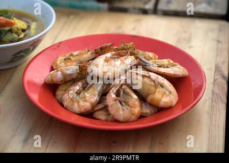 Primo piano dei gamberetti fritti serviti su un piatto sul tavolo. Foto Stock