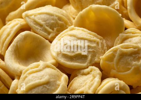 La pasta di orchiette cruda si avvicina all'intera cornice come sfondo Foto Stock