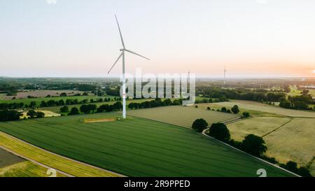 Grandi turbine eoliche con pale in campo vista aerea e cielo blu tramonto. Energia alternativa Foto Stock