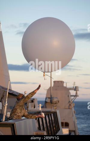 Orion Splash Down e Recovery Operations. Un membro del 45th Weather Squadron della Patrick Space Force base rilascia un pallone meteorologico dal ponte della USS Portland prima di abbattere la navicella spaziale Orion della NASA per la missione Artemis i l'11 dicembre 2022. Foto Stock